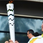 Imagem de um jovem segurando a tocha olímpica.