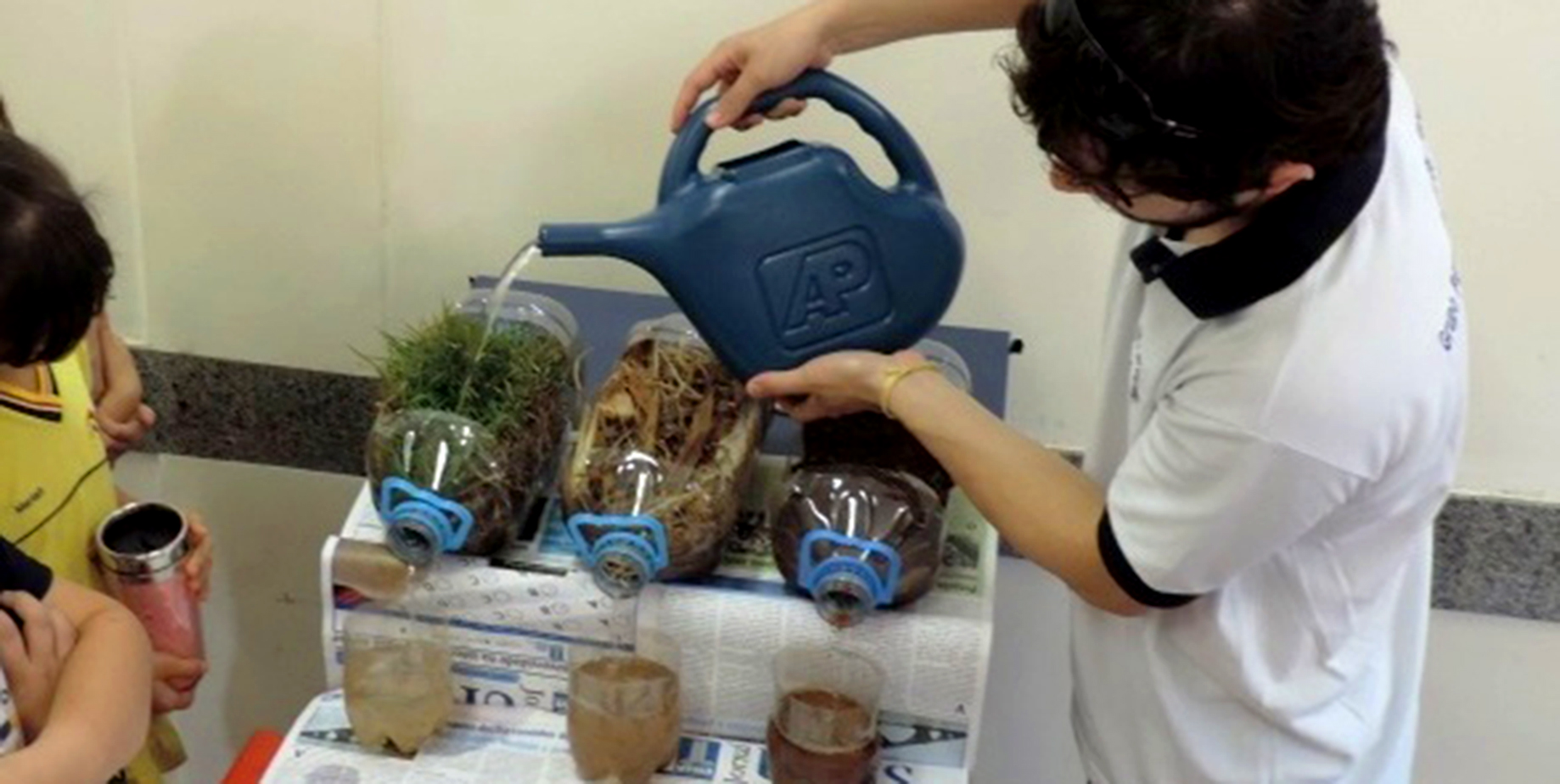 Imagem de um estudante regando plantas.