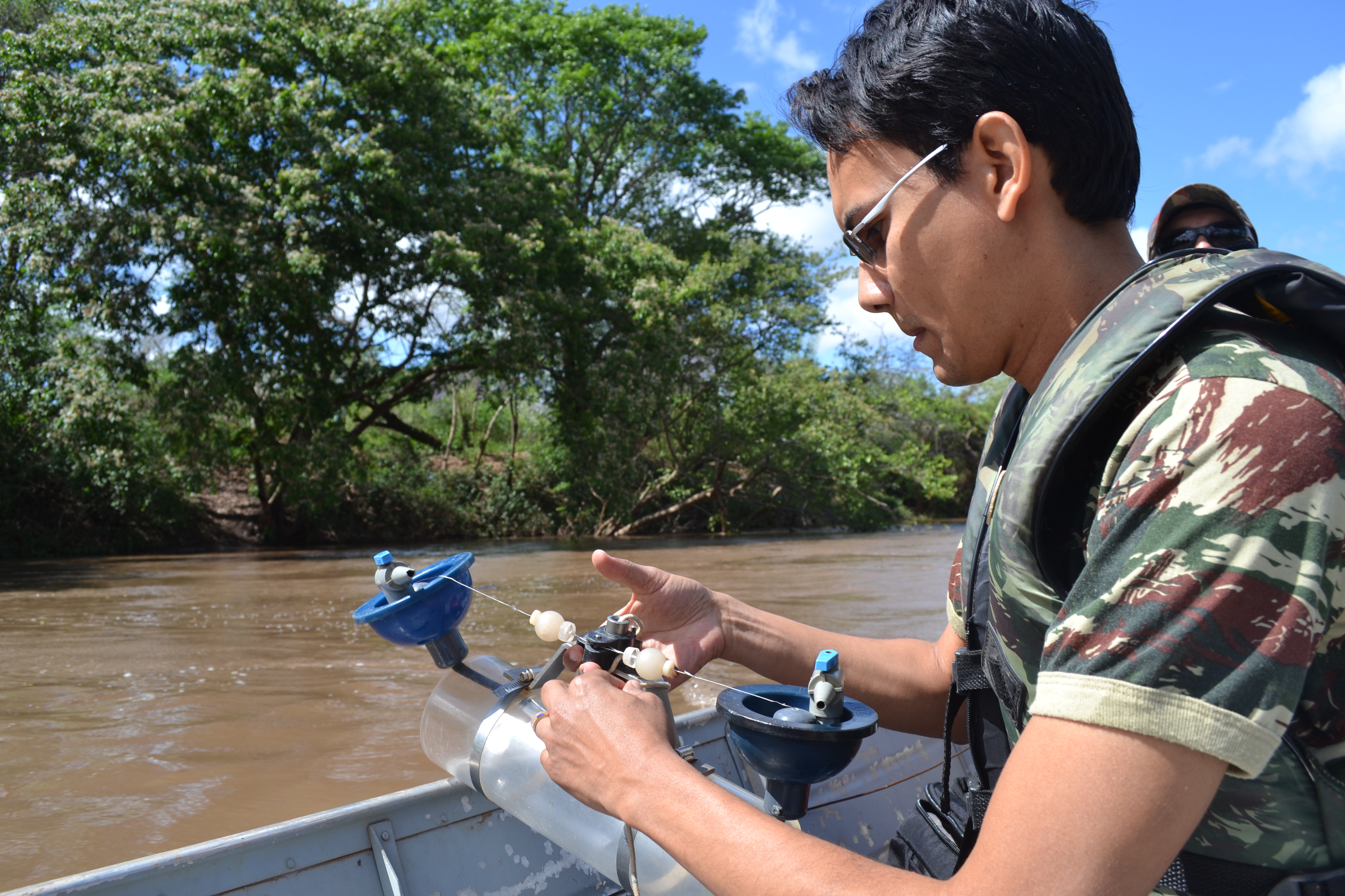 Imagem de um guarda ambiental manuseando um recipiente com água do Rio Apa